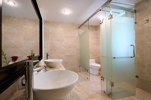 a bathroom with two sinks and a glass shower at Lang Co Beach Resort in Lang Co