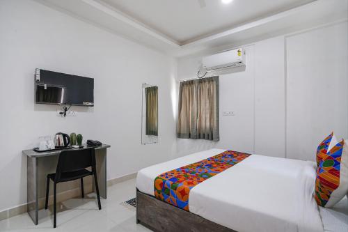 a bedroom with a bed and a desk and a television at FabHotel Rooms 27 - Nr Hitech City in Hyderabad