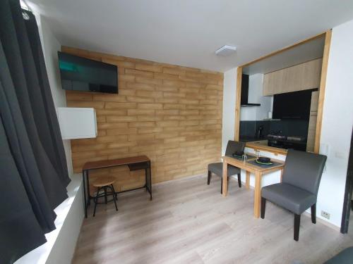 uma sala de estar com uma secretária, uma mesa e cadeiras em Le Cosy - Queen-size, full équipé, wifi, parking em Namur