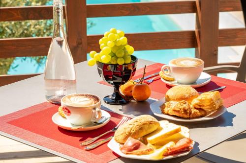 a table with plates of food and cups of coffee at Ollu e Stentu in Dolianova