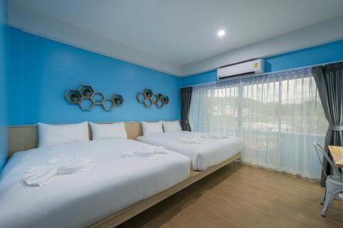 a bedroom with two beds and a blue wall at Otter House Aonang Intersection in Krabi town