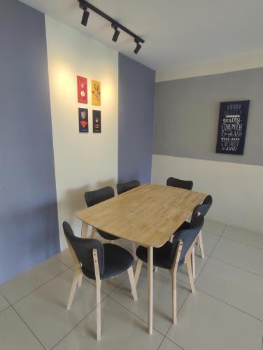 a dining room with a wooden table and chairs at Ipoh Manhattan Water Park Pool View Cozy Homestay in Ipoh
