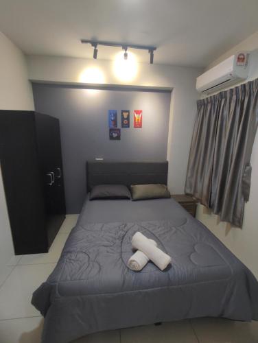 a bedroom with a bed with two towels on it at Ipoh Manhattan Water Park Pool View Cozy Homestay in Ipoh