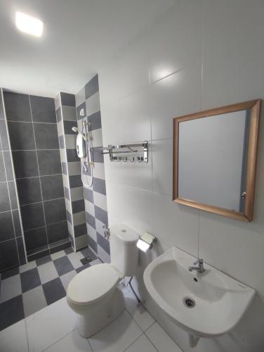 uma casa de banho com um WC, um lavatório e um espelho. em Ipoh Manhattan Water Park Pool View Cozy Homestay em Ipoh