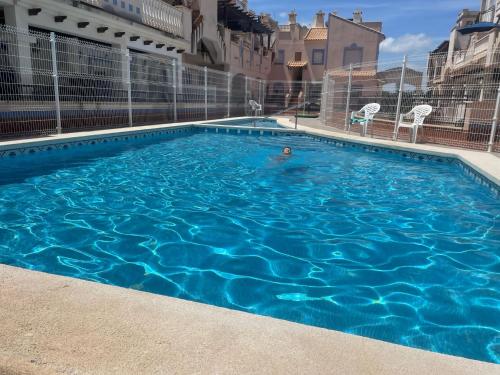 a person swimming in a large blue swimming pool at Chez Catherine et Thomas in Murcia
