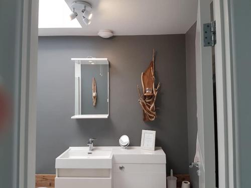 a bathroom with a white sink and a mirror at Horizon View in South Hayling