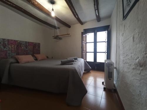 1 dormitorio con 2 camas y ventana en La Afortunaa, en Valdelarco