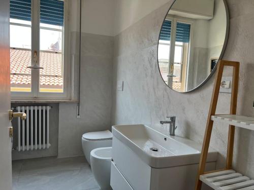 een badkamer met een toilet, een wastafel en een spiegel bij Fuori ci sta il mare! in Rimini