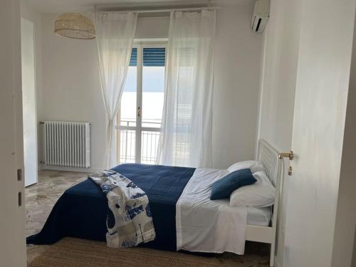 een slaapkamer met een bed en een raam bij Fuori ci sta il mare! in Rimini