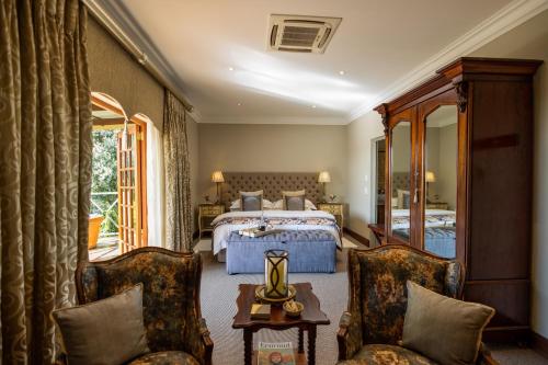 Andes Clarens Guesthouse في كلارينس: غرفه فندقيه بسرير وكرسيين