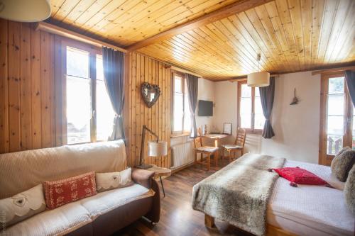 a living room with a bed and a couch at Hôtel Dents de Veisivi in Haudères