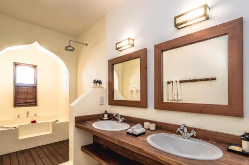 a bathroom with two sinks and a large mirror at Cinnamon House by The Serendipity Collection in Weligama