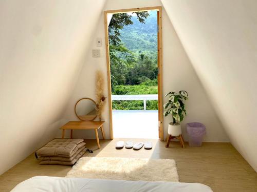 a room with a bed and a large window at Tid Khao Glamping & Bar in Tha Kradan