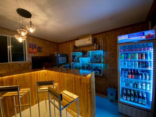 a bar in a restaurant with a drink cooler at Tid Khao Glamping & Bar in Tha Kradan