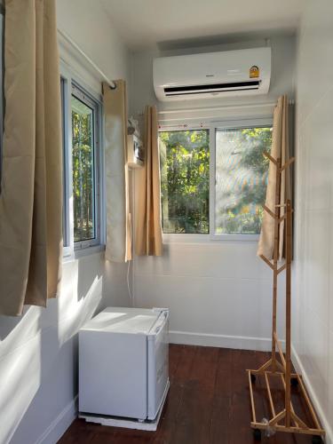 a small room with a heater and two windows at มานาตาฟาร์มสเตย์ in Ban Thong Noi (1)