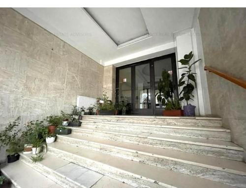 um grupo de escadas com vasos de plantas em frente a um edifício em Central Luxury Apartament Nr 5 ***** em Bucareste