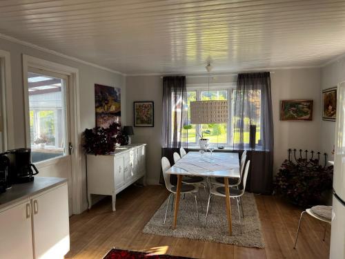cocina y comedor con mesa y sillas en Nice red cottage near the lake Hjalmaren and Vingaker en Vingåker