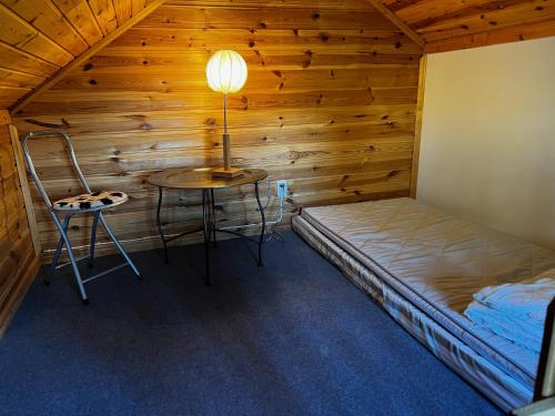 Pokój z łóżkiem, stołem i lampką w obiekcie Nice red cottage near the lake Hjalmaren and Vingaker w mieście Vingåker