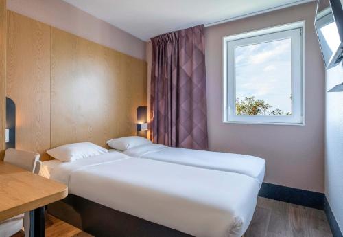 Ein Bett oder Betten in einem Zimmer der Unterkunft B&B HOTEL Niort Marais Poitevin Est