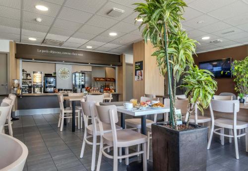 ein Restaurant mit einem Tisch, Stühlen und einer Theke in der Unterkunft B&B HOTEL Niort Marais Poitevin Est in Niort