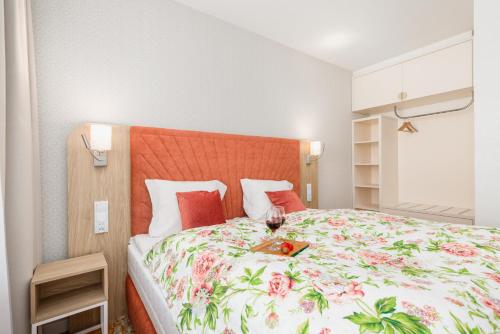 a bedroom with a large bed with a floral bedspread at Rent like home - Bel Mare F302 in Międzyzdroje