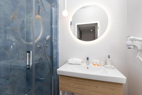 ein Bad mit einem Waschbecken und einer Dusche mit einem Spiegel in der Unterkunft Rent like home - Bel Mare F302 in Misdroy