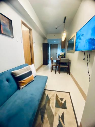 a living room with a blue couch and a table at SHORE RESIDENCES 1 BD UNIT FOR RENT in Manila