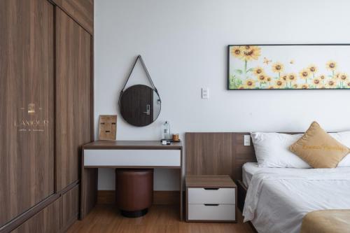 a bedroom with a bed and a desk and a mirror at Lamour homestay in Thôn Kim Long (1)
