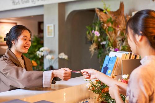 a man handing a woman a piece of paper at MTR Apartment & Hotel in Danang