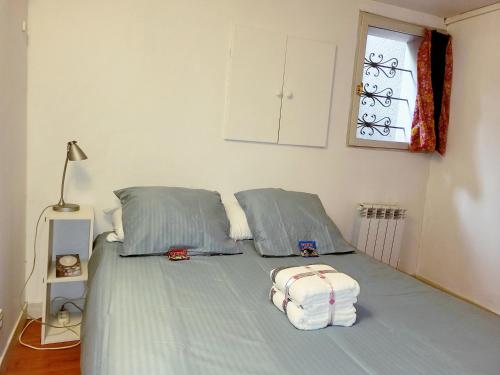a bed with two pillows and a bag on it at T2 au coeur de Blagnac- proche de tout- check in 24-24, parking in Blagnac