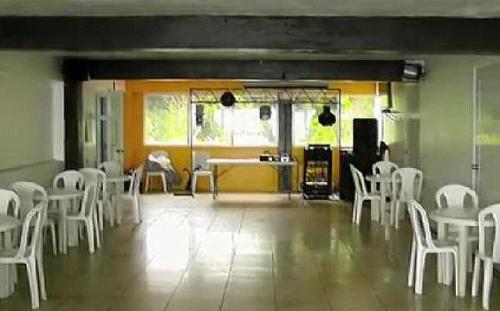 a room with white chairs and a table and a kitchen at Hotel Colombus in Aguada