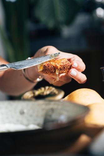 una persona che tiene un pezzo di cibo con un coltello di Primus Alacati Adult Only ad Alaçatı