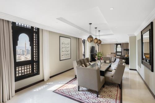 a living room with a dining table and chairs at Sofitel Shahd Al Madinah in Al Madinah
