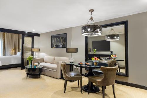 a living room with a couch and a table with chairs at Sofitel Shahd Al Madinah in Al Madinah