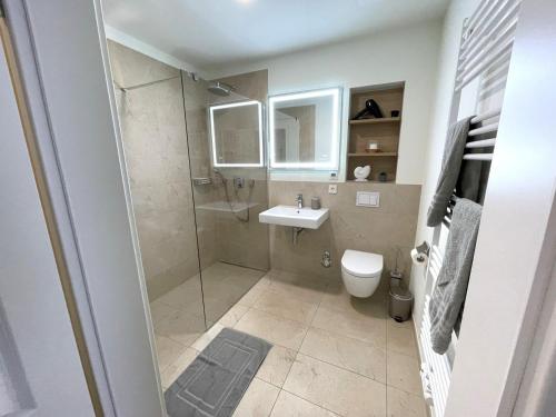 a bathroom with a shower and a toilet and a sink at Ferienwohnung Baltic Lagoon Ostsee in Fuhlendorf