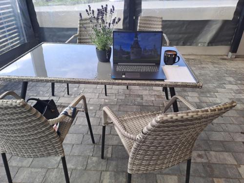 a laptop computer sitting on a table with two chairs at Figaro Apartaments in Gdynia