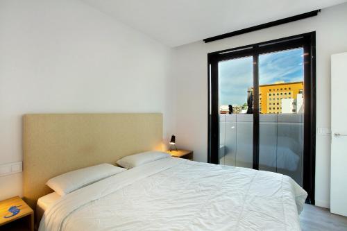 a bedroom with a large bed and a large window at Penthouse Aliseo on the beach in Las Palmas de Gran Canaria