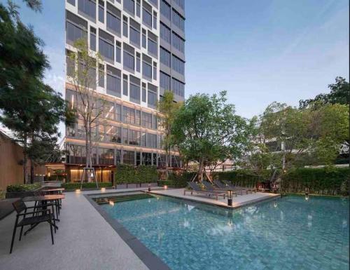 a swimming pool in front of a building at Ramada素坤逸87 Loft 空中酒吧 高层景观 BTS On Nut in Bangkok