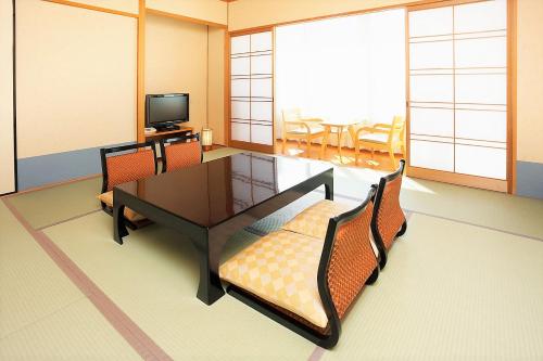 a room with a table and chairs and a tv at Arima Kirari in Kobe