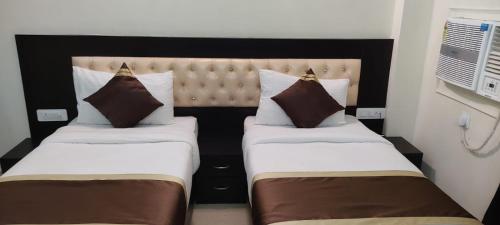 duas camas num quarto de hotel ao lado um do outro em J P PALACE em Kushinagar