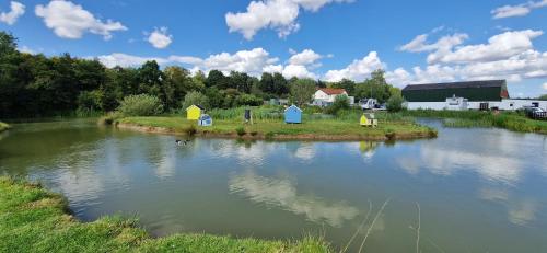 a river with a group of houses on the shore at seven acre farm campsite in Fiskerton