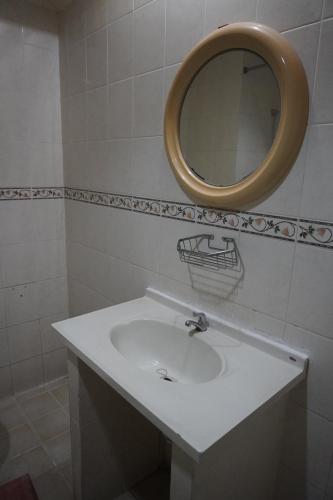 a bathroom with a white sink and a mirror at Ammara Legian By Vilarisi in Legian