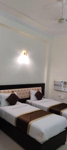 two beds in a hotel room with at J P PALACE in Kushinagar