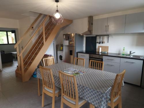eine Küche und ein Esszimmer mit einem Tisch und Stühlen in der Unterkunft Appartement rez de jardin in Saint-Martin-dʼUriage