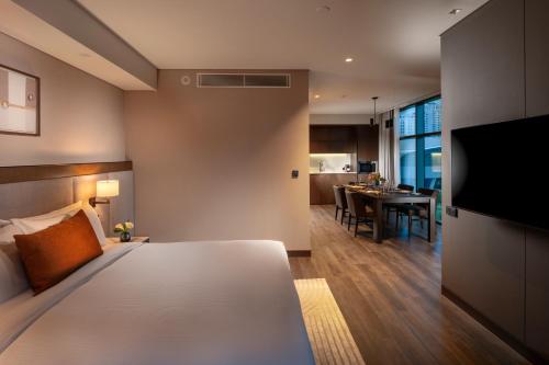 a hotel room with a bed and a dining room at DoubleTree By Hilton Seoul Pangyo Residences in Seongnam