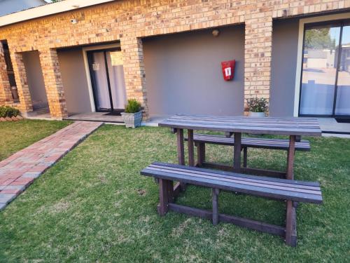 a picnic table in the grass in front of a building at A Step Ahead in Klerksdorp