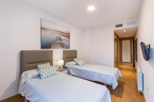 a room with two beds and a painting on the wall at Cartagena Centro in Cartagena