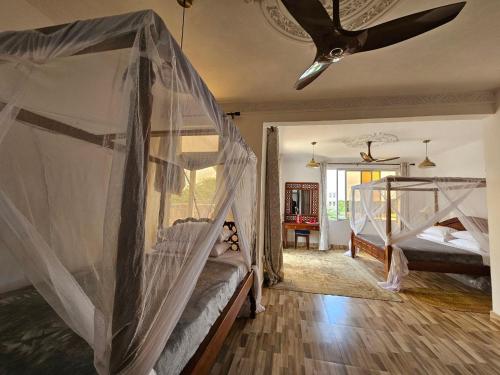 a bedroom with two bunk beds and a ceiling at Ras Kitao Holiday Villa in Lamu