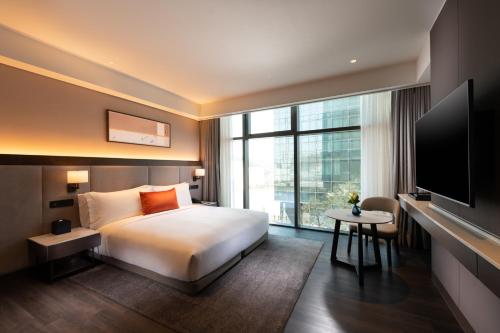 um quarto de hotel com uma cama e uma grande janela em DoubleTree By Hilton Seoul Pangyo Residences em Seongnam