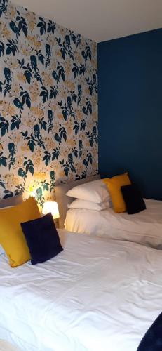 a bedroom with two beds and a floral wallpaper at The Lychgate in Caldicot